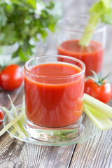 Tomato juice in a glass with celery and tomatoes