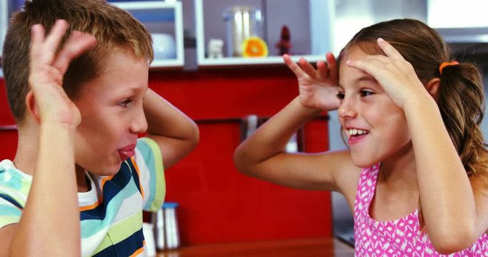 Siblings teasing each other in living room