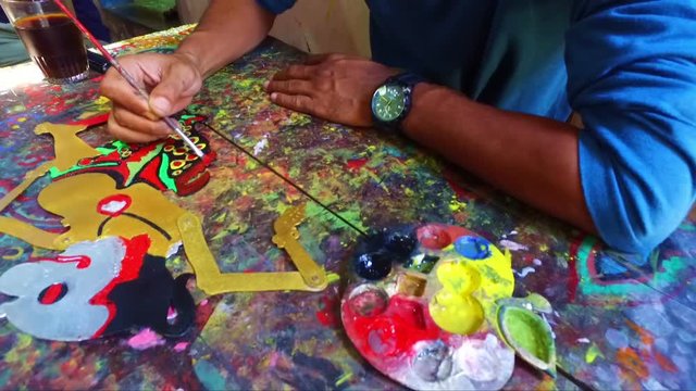 Painting a traditional wajang puppet in Indonesia