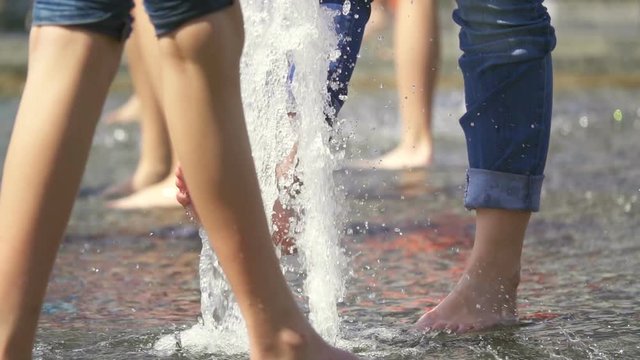 Girl's foot in the stream of a fountain, slow motion