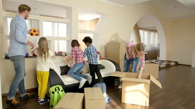 Family is unpacking things. People and cardboard boxes indoor.