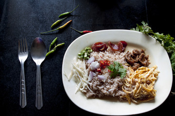 Rice Mixed with Shrimp paste on tile black color with spoon.