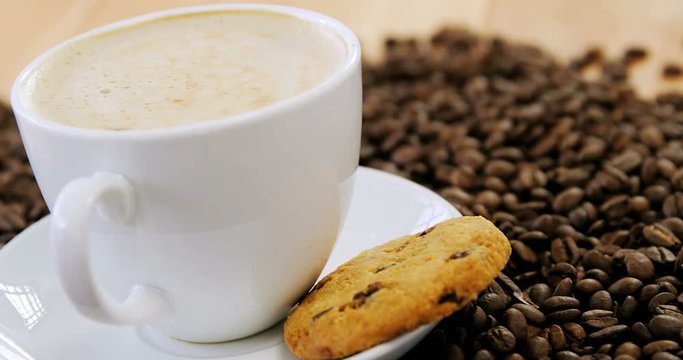 Coffee with cookie on roasted beans