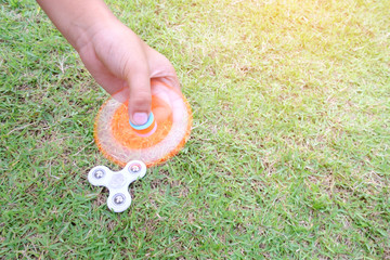 Boy holding play two fidget spinners, Fidget spinner white and ogange colour spinning stress...