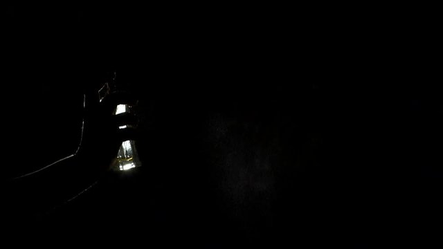 Close-up silhouette of a girl spraying perfume in the dark, slow motion.