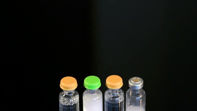 Four vial and insulin close-up on a black background. Vials of insulin with prolonged and short action.
