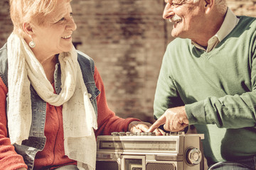 old couple happy retirement. elderly man and woman enjoy listening to evergreen music on vintage...