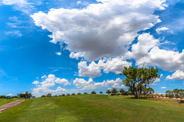 white clouds in blue sky above the golf field