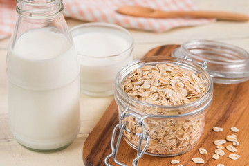 Oat flakes in glass jar and milk bottle