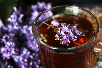 Lilac and flower tea in a glass cup

