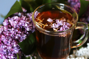 Lilac and flower tea in a glass cup

