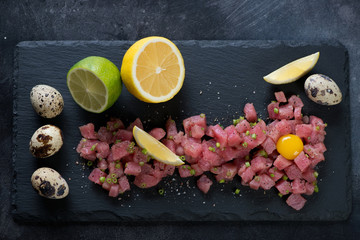 Stone slate tray with tuna tartare, view from above, horizontal shot