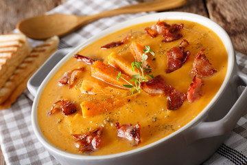 nutritious soup made of sweet potato with bacon and thyme close-up. horizontal