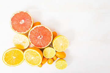 Different citrus on hite wooden table top view