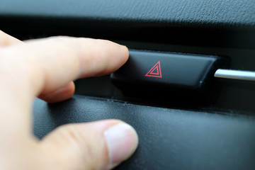 image of pressing emergency button on Car Dashboard 