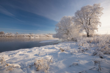 Russian Winter. Morning Frosty Winter Landscape With Dazzling White Snow And Hoarfrost,River And Saturated Blue Sky.Winter Small River At Sunny Day.Foggy  River Bank With Crispy Reeds In The Frost