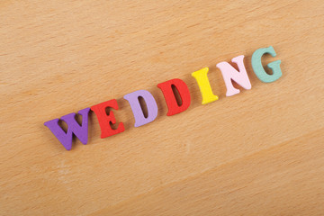 WEDDING word on wooden background composed from colorful abc alphabet block wooden letters, copy space for ad text. Learning english concept.