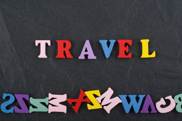 TRAVEL word on black board background composed from colorful abc alphabet block wooden letters, copy space for ad text. Learning english concept.