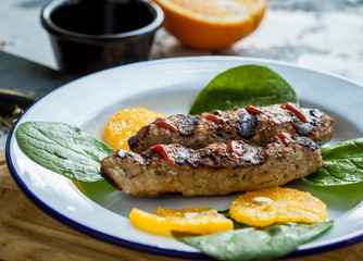 Kebab with sauce and oranges on a plate