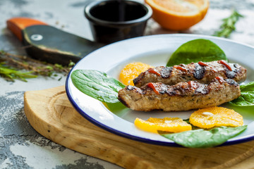 Kebab with sauce and oranges on a plate