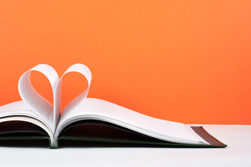 Old open hardback book, page decorate into a heart shape for love in Valentine's. love with open...