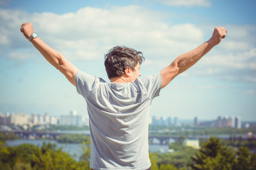 The guy feels freedom of life against the backdrop of a big city. Young man loves life