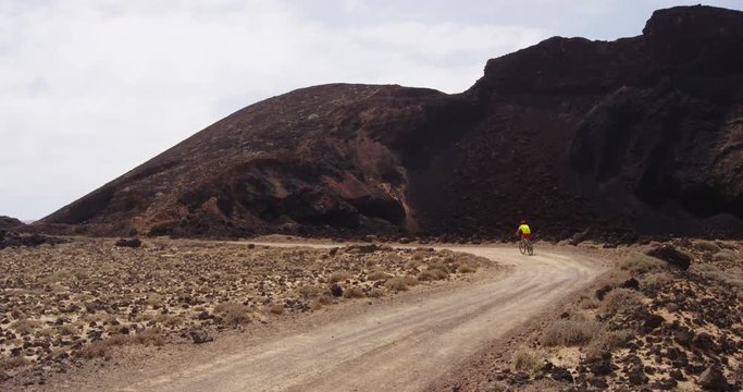 Man mountain biking on MTB bike trail. Man cycling enjoying healthy lifestyle and outdoor sports activity. Lanzarote, Canary Islands, Spain. RED EPIC SLOW MOTION.