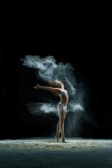Fototapeta na wymiar Girl in a cloud of white dust studio portrait