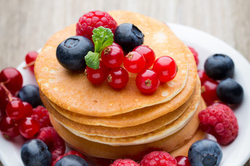 Stack of pancakes with blueberry and fresh berry.