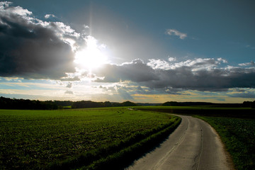 Sun and clouds above agricultural landscape
