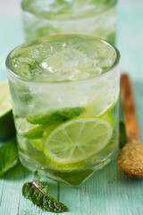 Mojito and ingredients on turquoise wooden surface