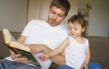 Obraz premium Dad is reading a book with a child. Young father. Father's Day