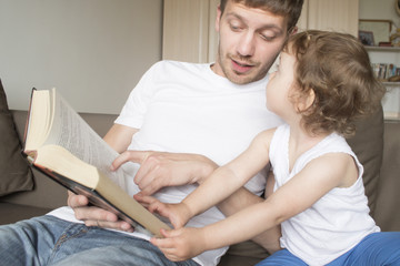 Obraz premium Dad is reading a book with a child. Young father. Father's Day