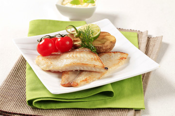 Skinless fish fillets with baked potato half