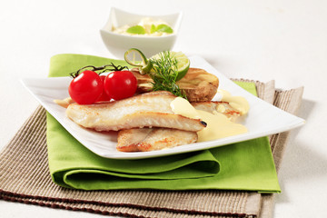 Skinless fish fillets with baked potato half