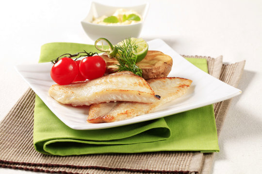 Skinless fish fillets with baked potato half
