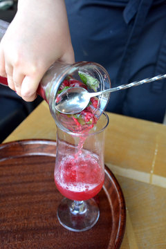 Summer lemonade with raspberry and leaves mint in a glass 