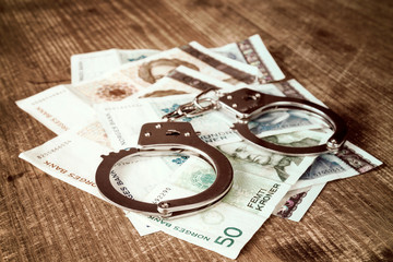 Norwegian kroner banknotes and metal handcuffs