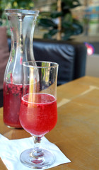 Summer lemonade with raspberry and leaves mint in a glass jug