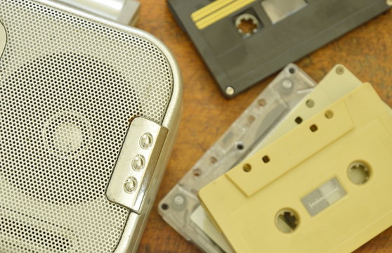 radio loudspeaker and cassette tape recorder on wooden table