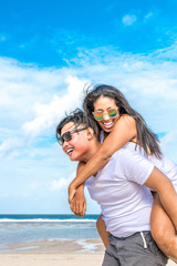 Asian couple having fun on the beach of tropical Bali island, Indonesia.