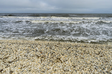 Landscape with sea view, waves and sea shells, clouds, photographed in Gura Portiţei, Romania, in cloudy spring day