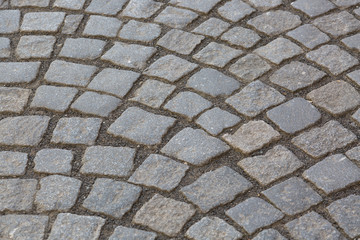 Granite cobblestoned pavement background. Stone pavement texture. Abstract background of old cobblestone pavement close-up in Prague