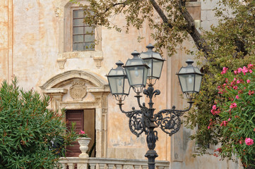 Fototapeta na wymiar Beautiful cast iron street lamps in front of the Church of St. Joseph on Piazza IX Aprile - Taormina, Sicily, Italy