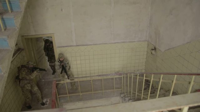 Guerilla partisan warriors operation in urban environment. Soldiers entering building. Anti terrorist operation battlefield maneuvers training.