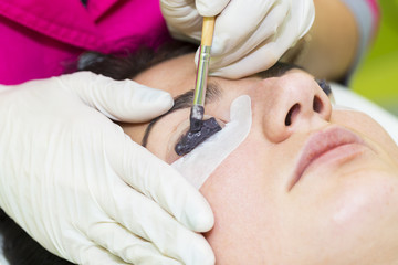 Woman on the procedure for eyelash extensions, eyelashes lamination 