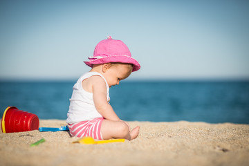 Little girl playing with bach toys in sand