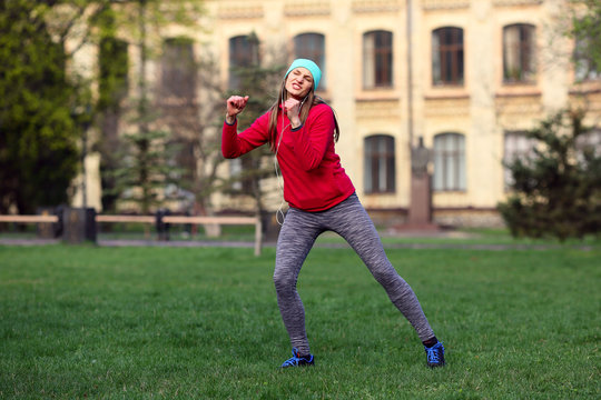 Funny young woman sport woman dancing on grass