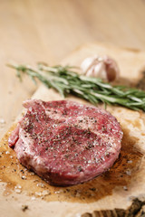 raw rib eye steak on board closeup, shallow focus