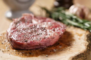 raw rib eye steak on board closeup, shallow focus